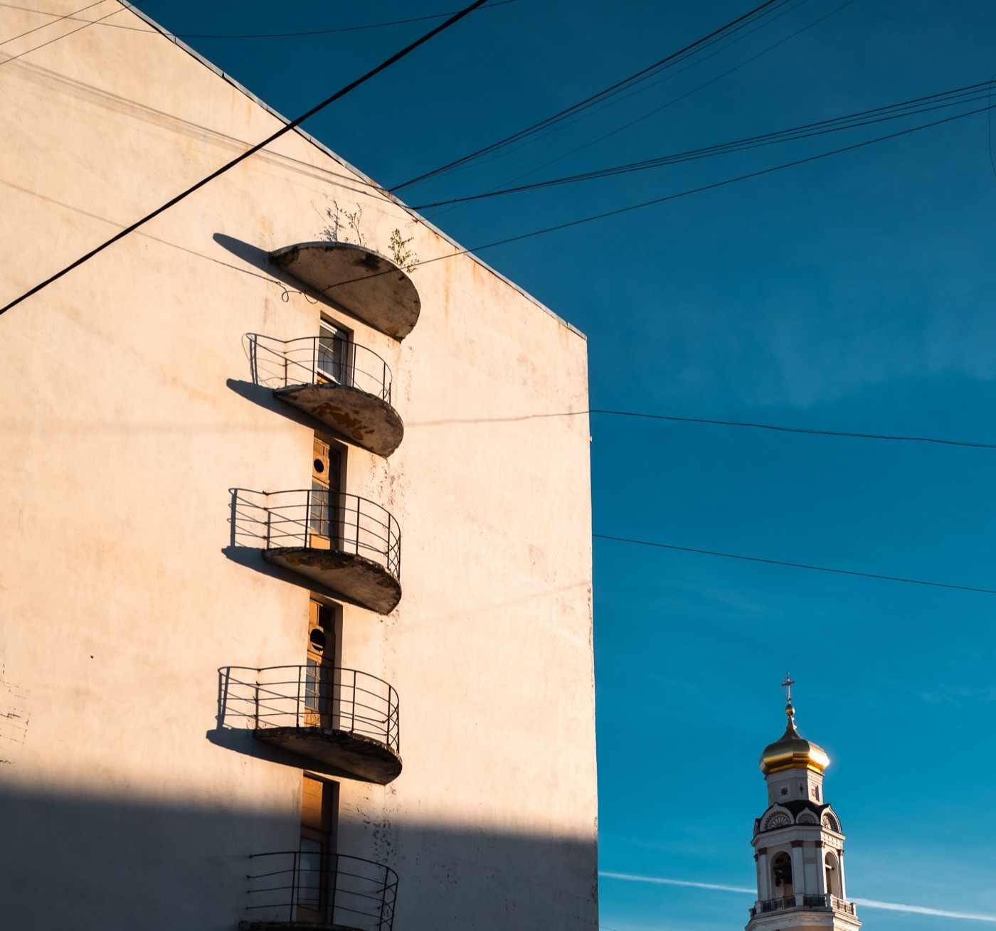 Sunlit modernist balconies beneath a deep blue sky