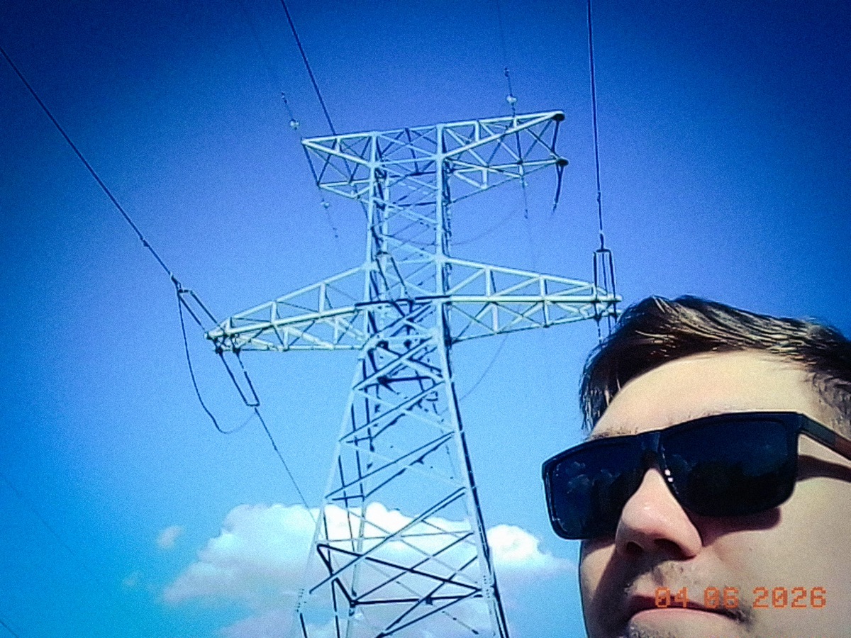 Self-portrait beneath a power line tower, shot on Charmera