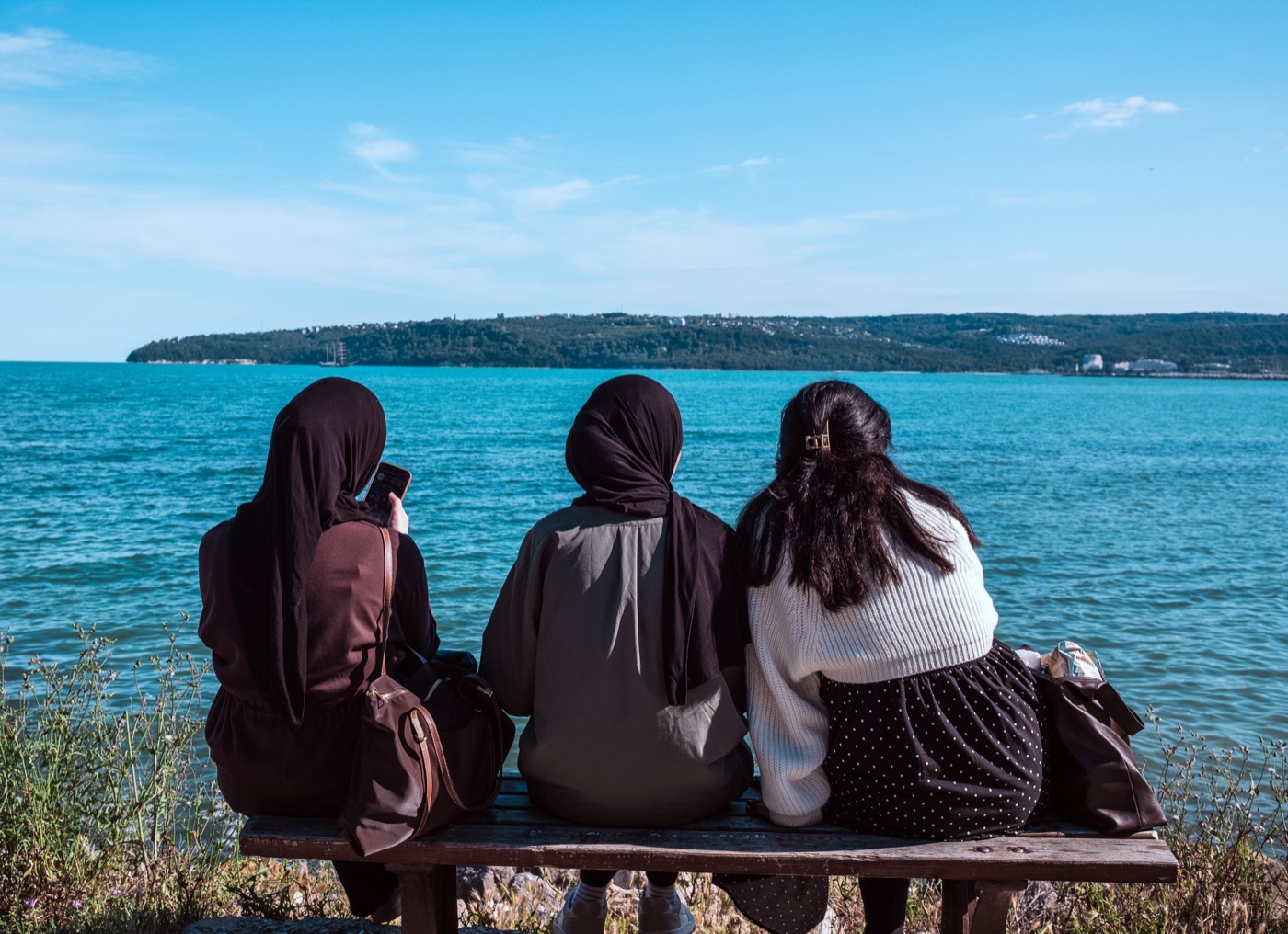Three friends sitting together by the sea